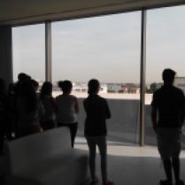 Mes élèves, dans la salle d’exposition permanente, observent les bâtiments de l’ancien camp que permet la façade transparente